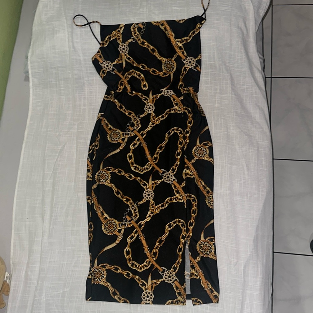 Woman Large Cocktail Dress with Black and Gold Chains stamped around the dress.